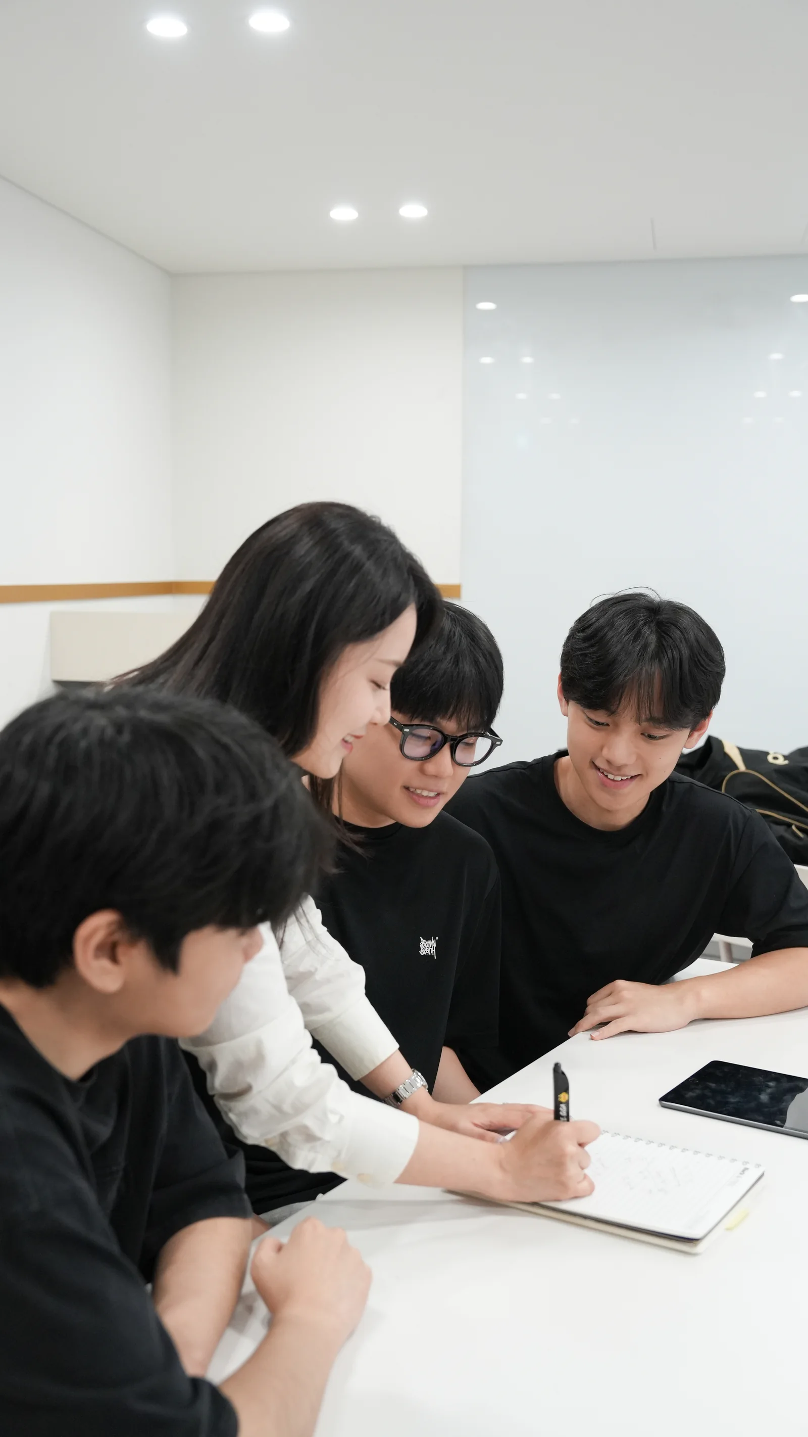 선생님과 학생들이 자료를 보며 함께 이야기하는 모습